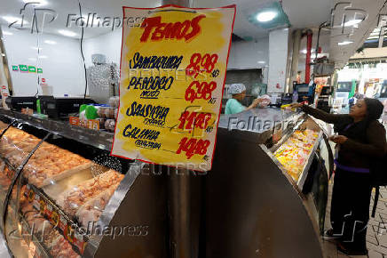A woman stands at a chicken stall in a market in Sao Paulo