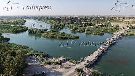 A drone view shows remnants of a destroyed bridge alongside the citizen-built sand bridge, in Deir El-Zor