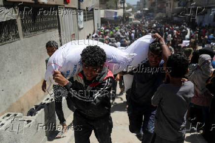 Palestinians gather to receive aid supplies at a distribution center, in Gaza City