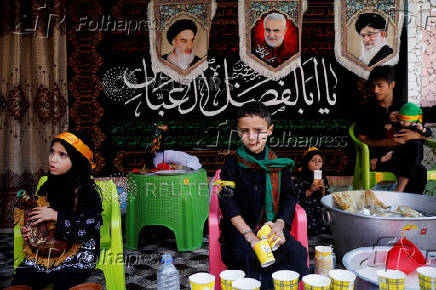 Shi'ite children distribute water in the interiors of Dal Lake during a Muharram procession ahead of Ashura in Srinagar