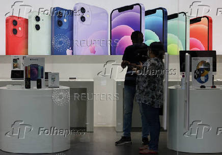FILE PHOTO: A salesperson speaks to a customer at an Apple reseller store in Mumbai