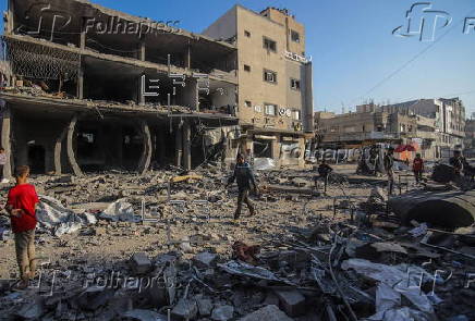 Palestinians inspect destroyed building after Israeli airstrike in Gaza City