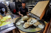 Palestinian workers pack bread in a bakery that returned to operation after being closed due to a flour shortage, in Deir Al-Balah