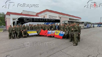 Russian soldiers pose for cameras in Belarus after release from Ukraine on the third day of POW exchange