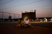 A Muslim man reads verses on his mobile phone at Jama Masjid on the occasion of Eid al-Adha, in the old quarters of Delhi