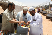 Iranian pilgrims who were rerouted through Iraq eat free meals provided by volunteers at the Arar border crossing