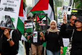 Activists carry placards and Palestinian flags during a protest against Israel and in support of Palestinians in Gaza, outside the U.S. embassy in Jakarta