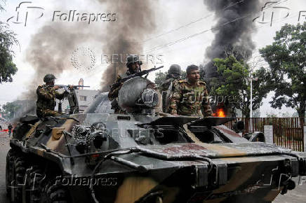 Soldiers sit atop an APC after armed forces were deployed, following a clash during a National Citizen Party rally, in Gopalganj