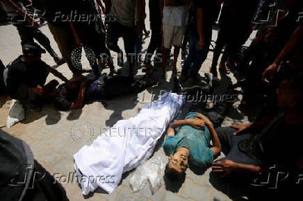 Palestinians gather around casualties of Israeli fire, who were seeking aid in northern Gaza, according to medics, in Gaza City