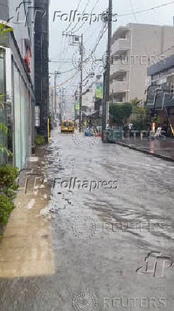 A car drives down a flooded street amid inclement weather due to Typhoon Peipah, in Kamakura