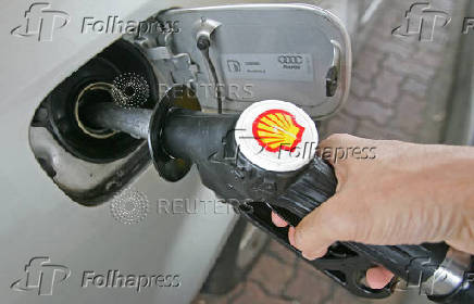 FILE PHOTO: A driver fills up with fuel at a Shell petrol station in southern England