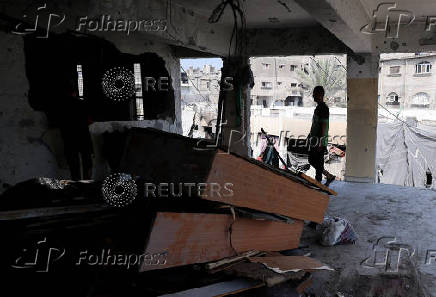 Palestinians inspect the damage following an overnight Israeli strike on a school sheltering displaced families, in Jabalia