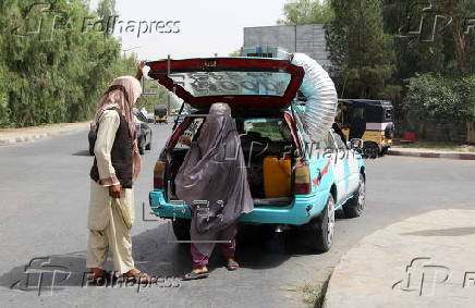 Taxi drivers install locally made air coolers to beat the heat in Kandahar