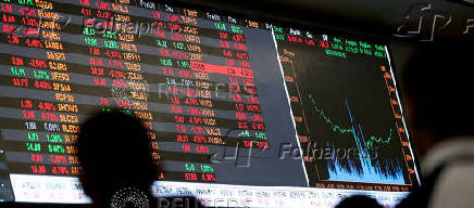 FILE PHOTO: People look at an electronic board at the stock market in Sao Paulo