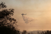 A firefighting helicopter drops water to extinguish fire at the area of Souni near Limassol,