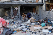 Palestinians inspect the site of an Israeli strike on a house, in Khan Younis