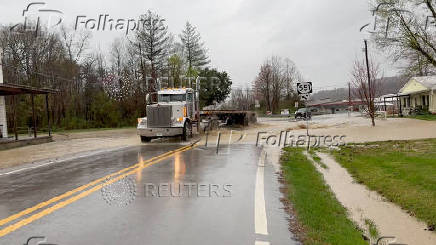 Vehicles make their way through a flooded road in Casey county, Kentucky