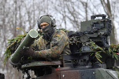 FILE PHOTO: A soldier installs a military system on a tank during a NATO exercise in Marienberg, Germany