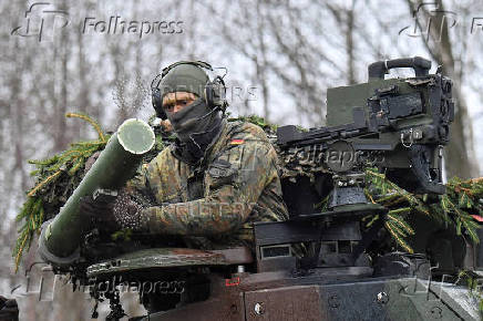 FILE PHOTO: A soldier installs a military system on a tank during a NATO exercise in Marienberg, Germany