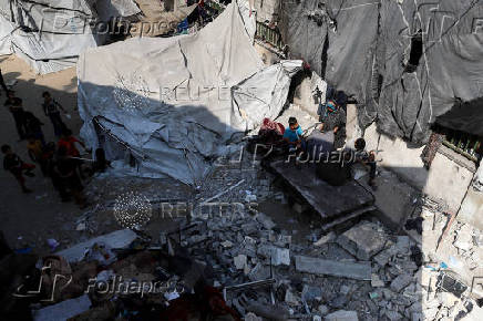 Palestinians inspect the damage following an overnight Israeli strike on a school sheltering displaced families, in Jabalia