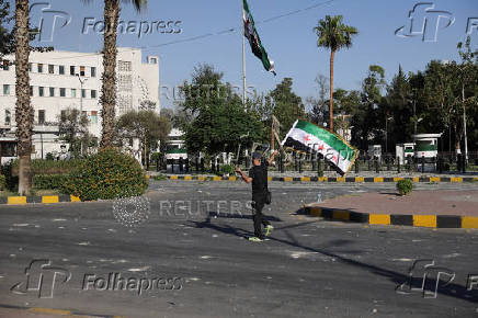 People gather near a damaged site, in Damascus
