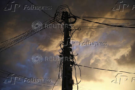 FILE PHOTO: Electric poles with electrical and telephone cables are seen in Bangkok