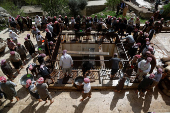 Yazidi men press olives to extract oil at the Lalish temple as part of a religious ritual in preparation for the Yazidi Red Wednesday festival, in Shekhan district near Duhok province