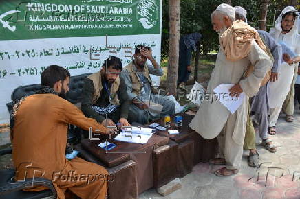 Afghan families, returned from neighboring Pakistan, receive food rations distributed by the Tawheed Charity Foundation in Jalalabad