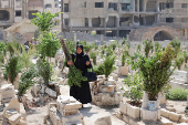 A person visits the graves of their relatives at a cemetery, on the first day of the Muslim holiday of Eid al-Adha, in Damascus