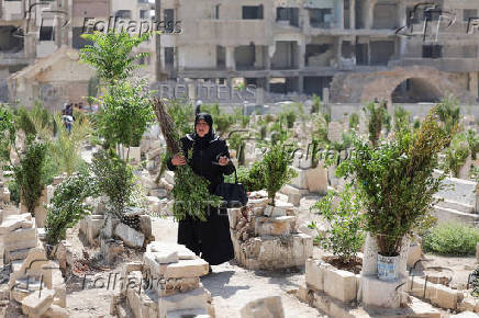 A person visits the graves of their relatives at a cemetery, on the first day of the Muslim holiday of Eid al-Adha, in Damascus