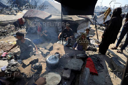 Displaced Palestinians who have not received humanitarian aid survive on leftover food, in Gaza