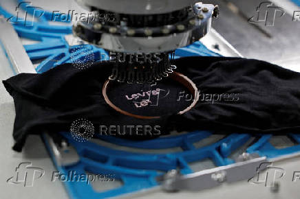 An automated embroidery machine stitches Levi's logo on t-shirt in a garment manufacturing unit on the outskirts of Ahmedabad