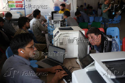 An Afghan national, who was deported from Iran, waits to register himself inside an IOM station at a camp for returning migrants near Islam Qala border crossing