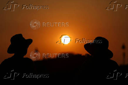 People watch the sunset from the Jardin des Tuileries