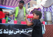 Volunteers distribute cold drinks on a roadside in Hyderabad
