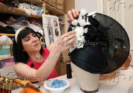 Milliner Merve Bayindir works on one of her bespoke hats ahead of the Ascot horse racing festival, in London