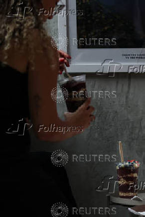 A woman consumes an Acai smoothie at an Oakberry Acai bowl location in New York City