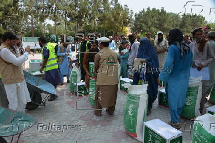 Afghan families, returned from neighboring Pakistan, receive food rations distributed by the Tawheed Charity Foundation in Jalalabad