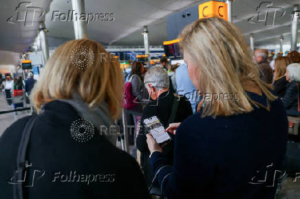 FILE PHOTO: Travellers at Heathrow Airport amid cyberattack disruptions, in Greater London