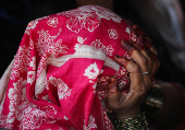 Pakistani citizen Baskari holds her head as she and her relatives prepare to leave India after India revoked all visas issued to Pakistani citizens, at the Attari-Wagah border crossing near Amritsar