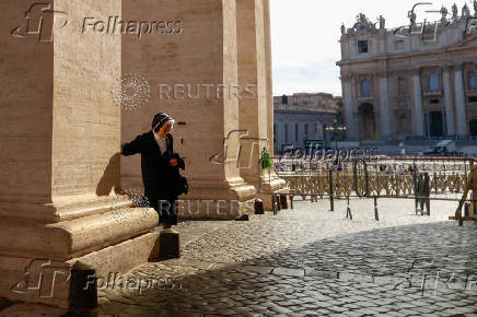 A nun walks past the colonnades of St. Peter's Square at the Vatican ahead of the May 7 conclave to elect a new pope, as seen from Rome