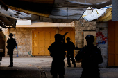 Israeli troops stand guard during a weekly settlers' tour in Hebron
