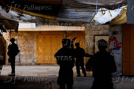 Israeli troops stand guard during a weekly settlers' tour in Hebron