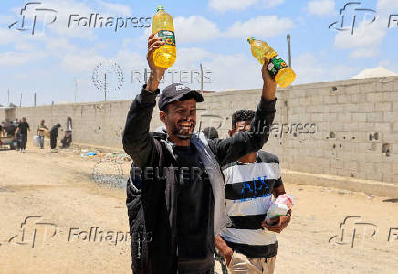 Palestinians carry aid supplies they received from the U.S.-backed Gaza Humanitarian Foundation, in Khan Younis