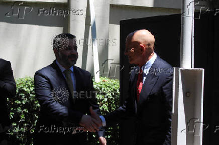 Syrian Foreign Minister Asaad Hassan al-Shibani shakes hands with U.S. envoy for Syria Thomas Barrack at U.S. ambassador's residency in Damascus