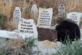 Palestinians visit graves of their relatives at a cemetery in Jenin camp