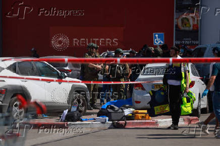 Israeli security personnel stand guard near the scene of a stabbing attack, in Gush Etzion