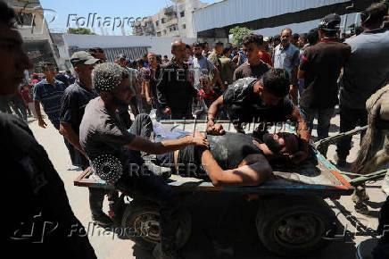 Palestinians transport casualties of Israeli fire, who were seeking aid in northern Gaza, according to medics, in Gaza City