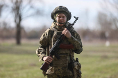 Young recruit of the Ukrainian Armed Forces poses for a picture in Kyiv region