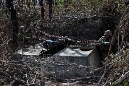 Servicemen of the Ukrainian Armed Forces fire a self-propelled howitzer towards Russian troops at a front line in Donetsk region